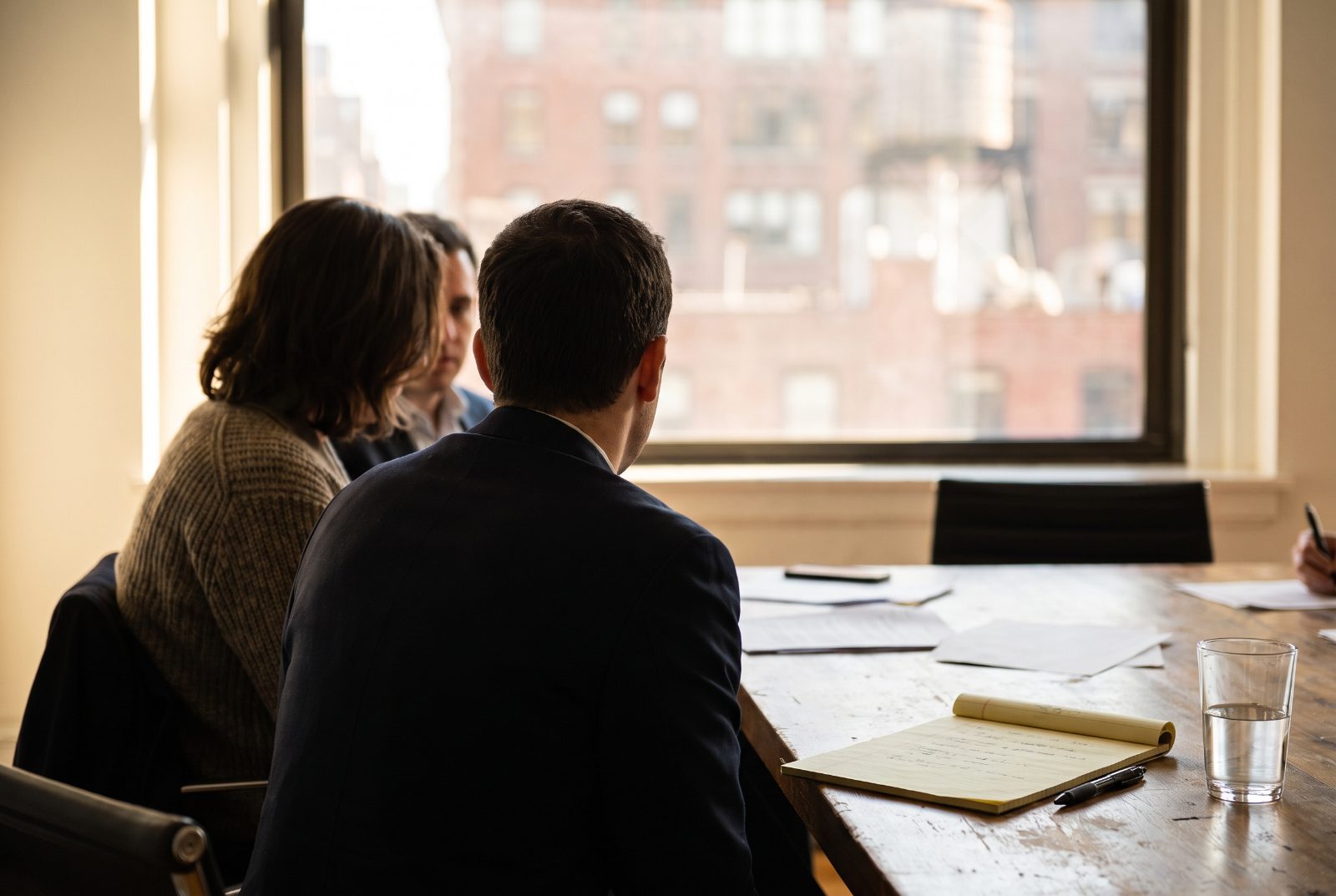 A professional interpreter in conversation with a client in a bright NYC office.