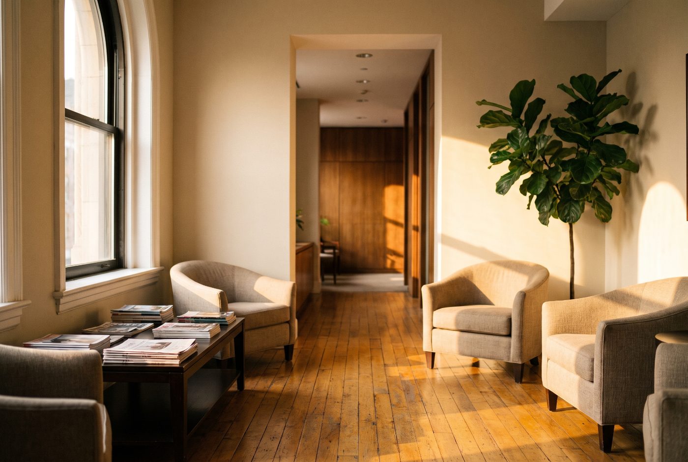 Quiet law office reception and waiting area in morning light, with empty chairs and a corridor leading away